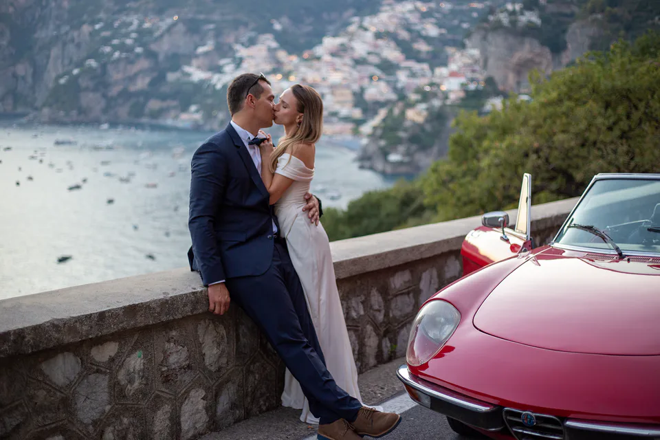 Elegant couple portrait beside a vintage car