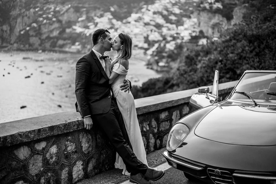Black and white couple portrait beside a vintage car